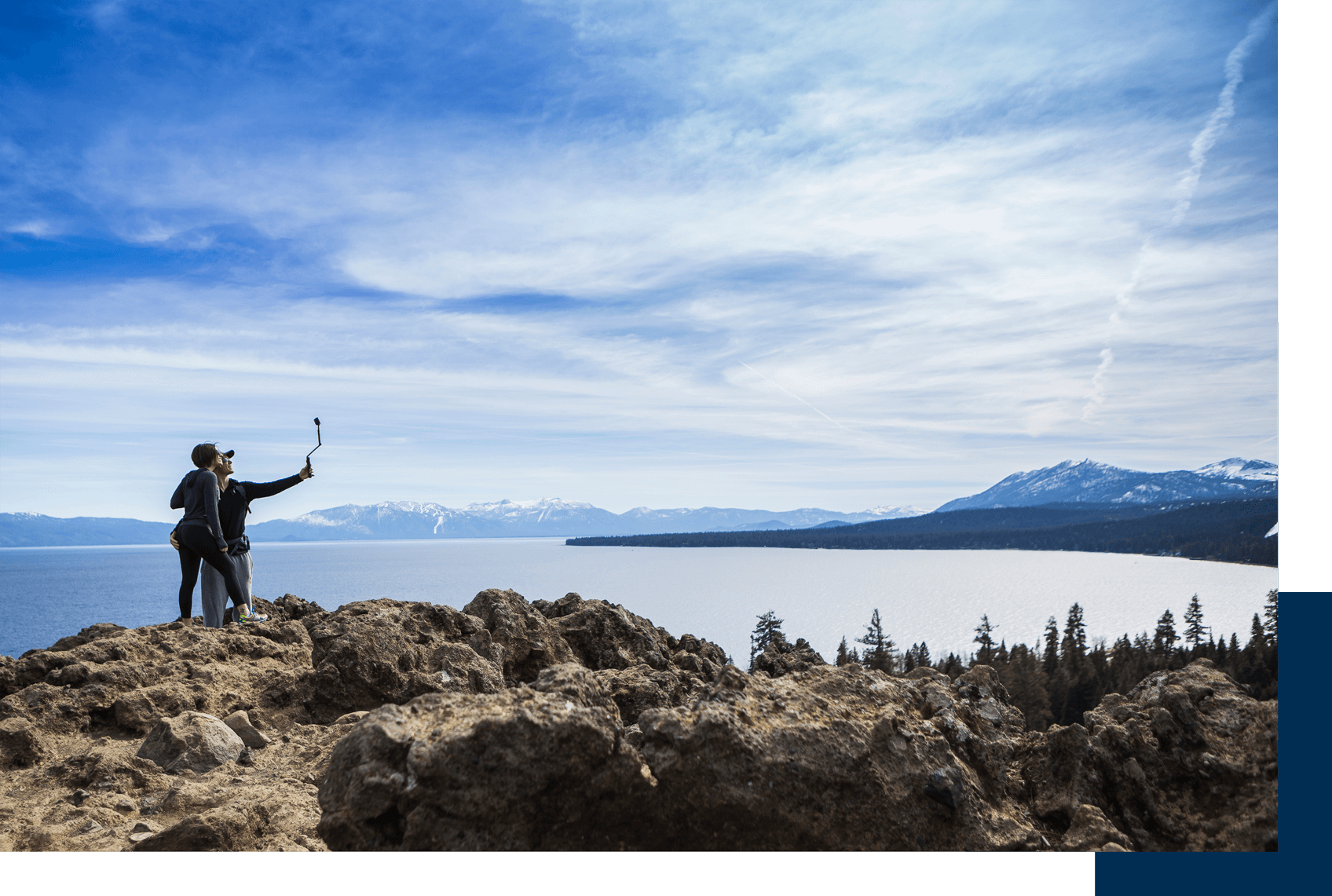 A person standing on top of a hill near the ocean.