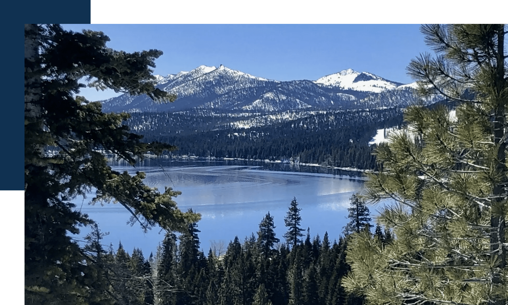 A lake surrounded by trees and mountains.